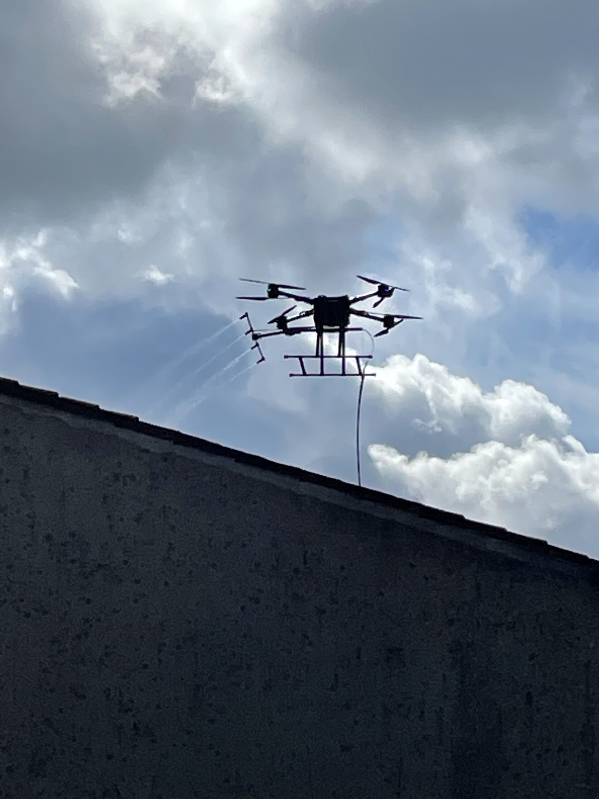 Frone qui néttoie les panneaux solaires d'un hangar à l'aide d'un tuyau