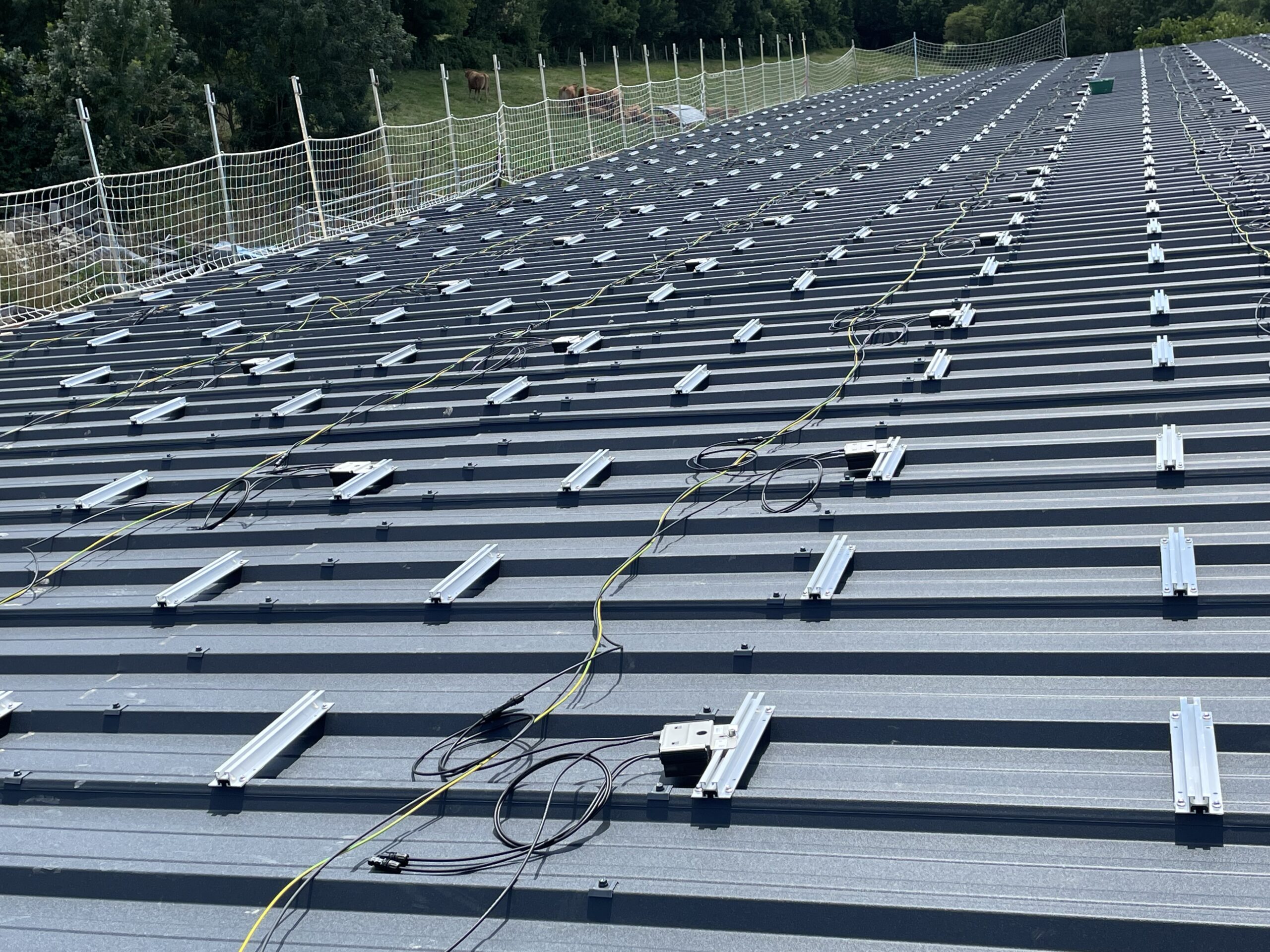 Fixation avant panneaux solaires sur le toit d'un hangar