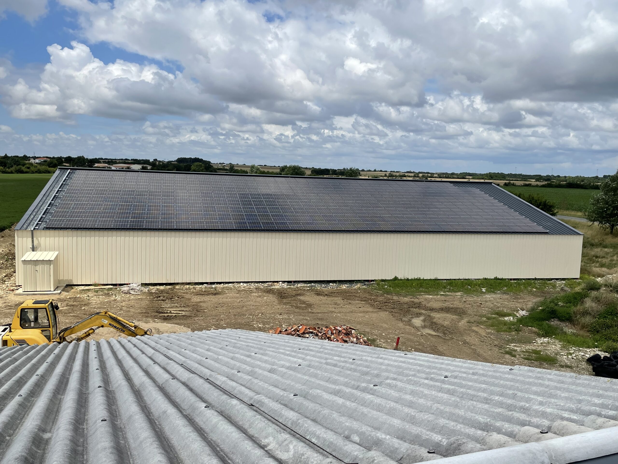 Hangar couvert de panneaux solaires vue depuis le toit d'un autre hangar